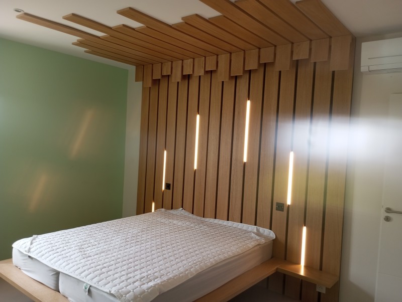 Tête de lit en chêne avec persiennes et leds sur mesure dans le sud de la France à Aix en Provence.