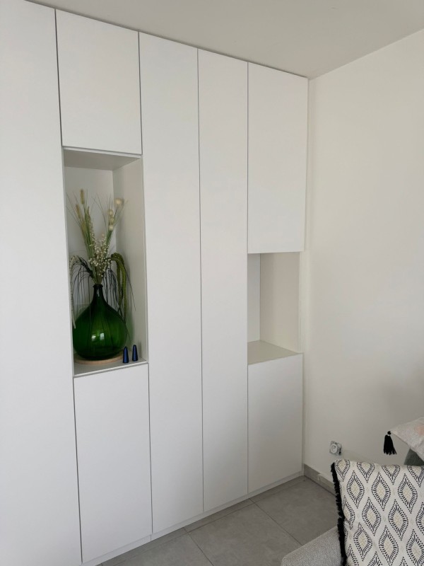 Placard de rangement blanc épuré sans poignée avec niches ouvertes à Ventabren dans le sud de la France.