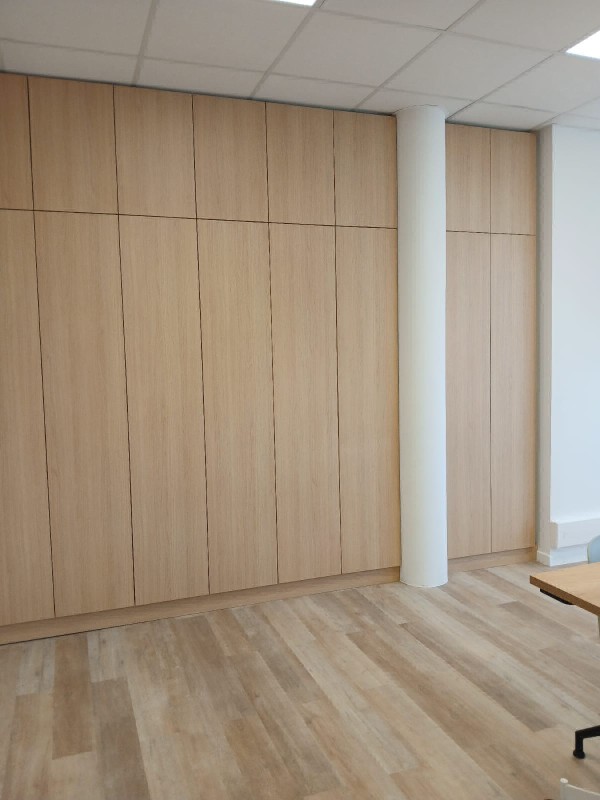 Réalisation d’un placard mural sur mesure en chêne clair avec ouverture pousse-lâche pour salle de réunion à Marseille